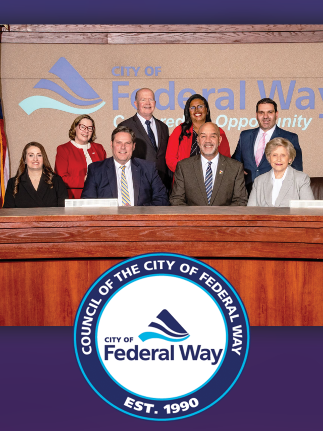 Federal Way City Council members pose for a group photo in the council chambers in front of the City of Federal Way logo.